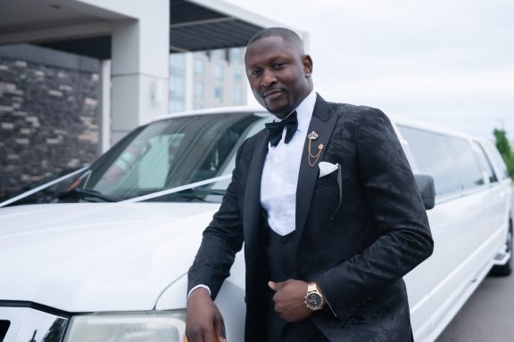 groom standing next to a limo