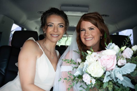 bride with maid of honour in limo