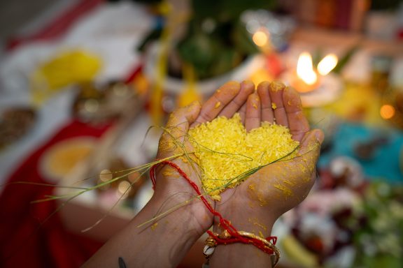 Indian bride holding rice in the shape of a heart